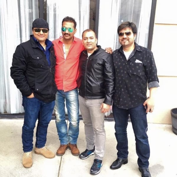 Four men, possibly Everest Cuisine staff, pose together, smiling at the camera.