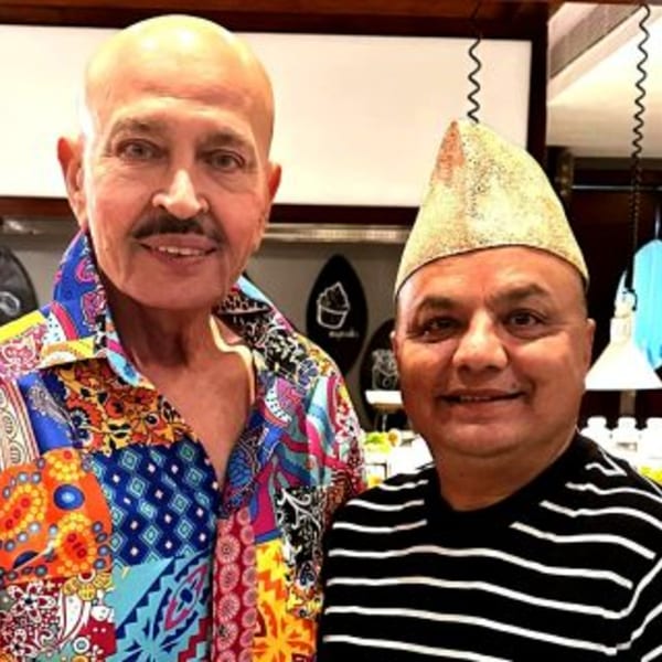Two men, one in a colorful patterned shirt and the other in a striped shirt and traditional hat.