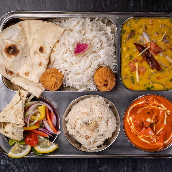 Everest Cuisine's Indian thali with naan, rice, dal, chicken tikka masala, salad, and dessert.